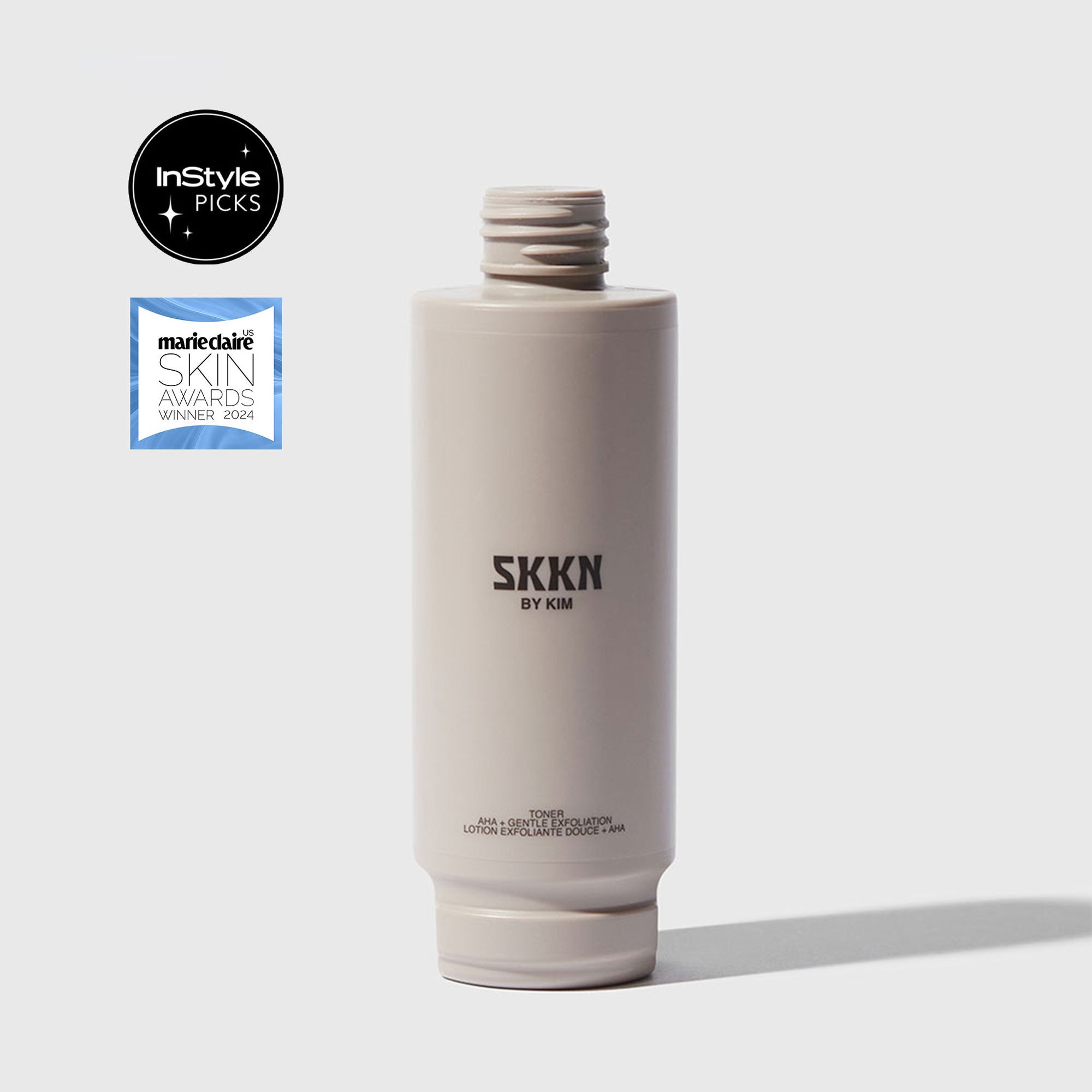 Opened bottle of SKKN BY KIM Toner Pore Reducing next to cap