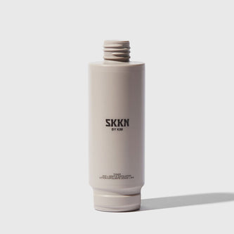 Opened bottle of SKKN BY KIM Toner Pore Reducing next to cap