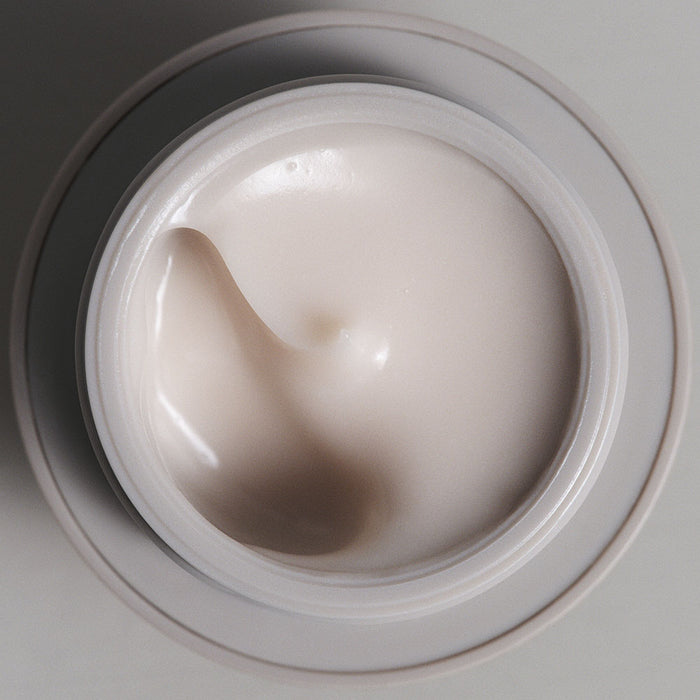 Opened bottle of SKKN BY KIM Eye Cream Plumping Peptides next to cap